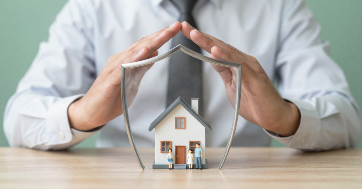 A metal shield protecting a miniature house and family figures, symbolizing asset protection in the US.